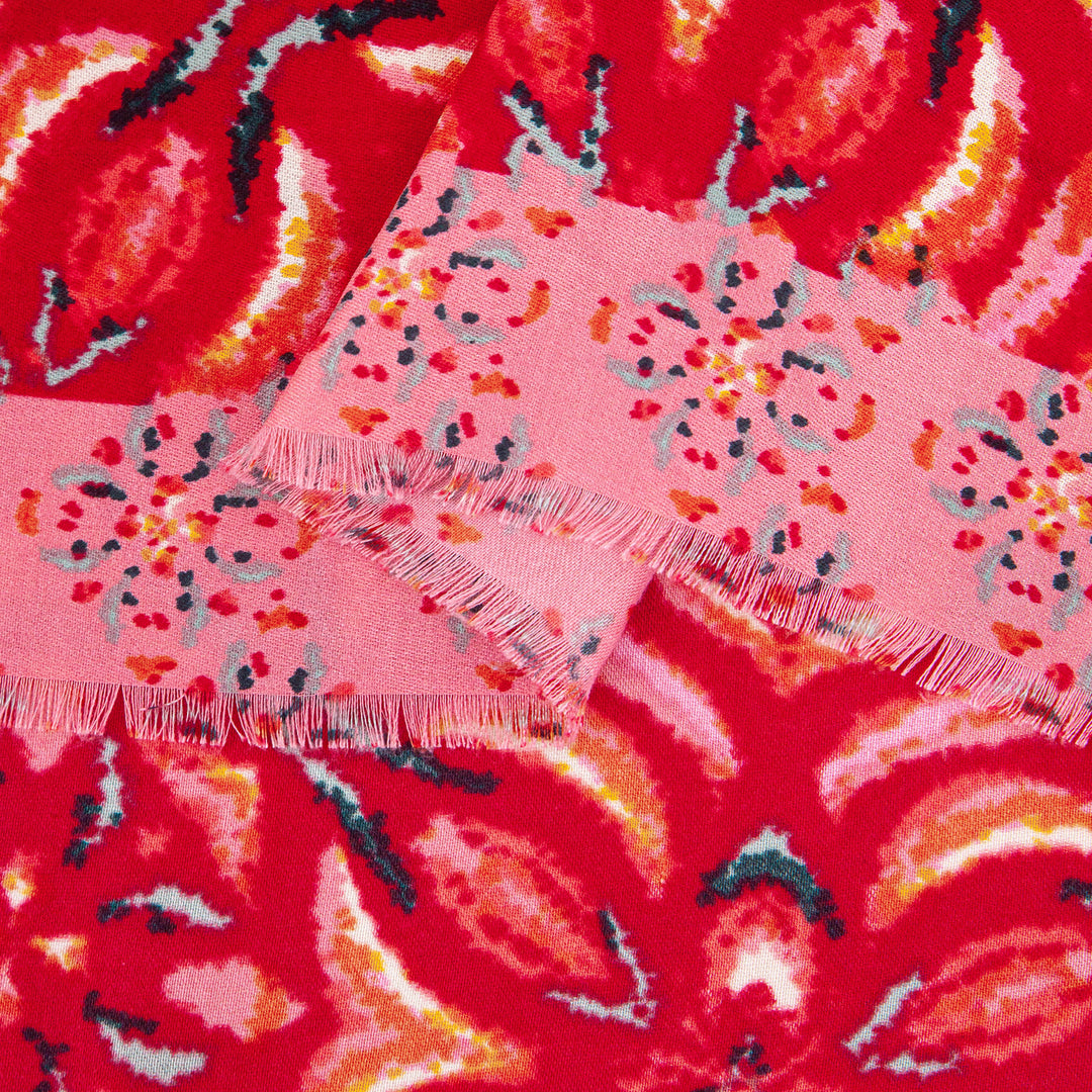 close up of the soft viscose fabric, red colourway and contrasting pink floral print border is clearly visible