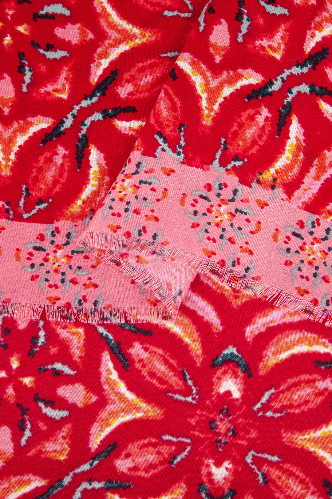 close up of the soft viscose fabric, red colourway and contrasting pink floral print border is clearly visible