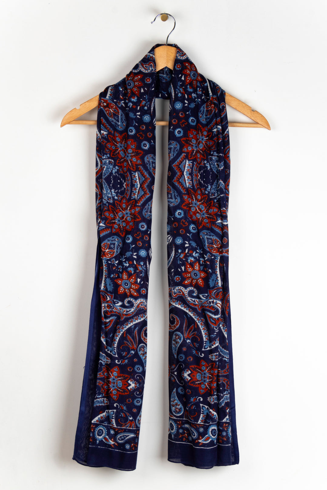 showing the scarf draped around a coat hanger, showing the all over pattern and how it would look when worn