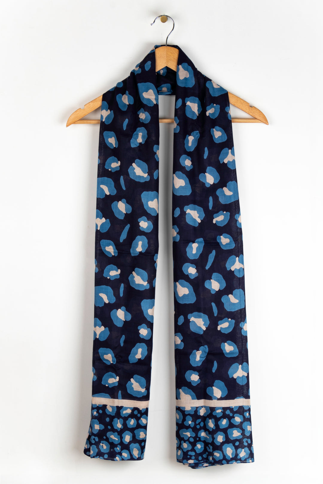 showing the scarf draped around a coat hanger, showing the all over pattern and how it would look when worn