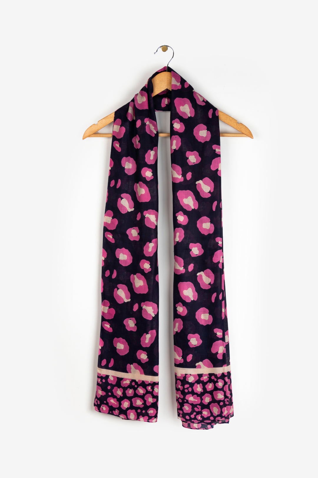 showing the scarf draped around a coat hanger, showing the all over pattern and how it would look when worn