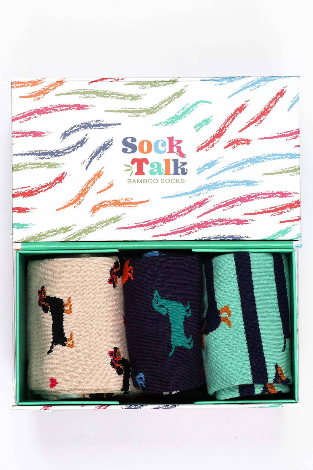 white gift box with a multicoloured brushstroke pattern and three pairs of sausage dog pattern bamboo socks