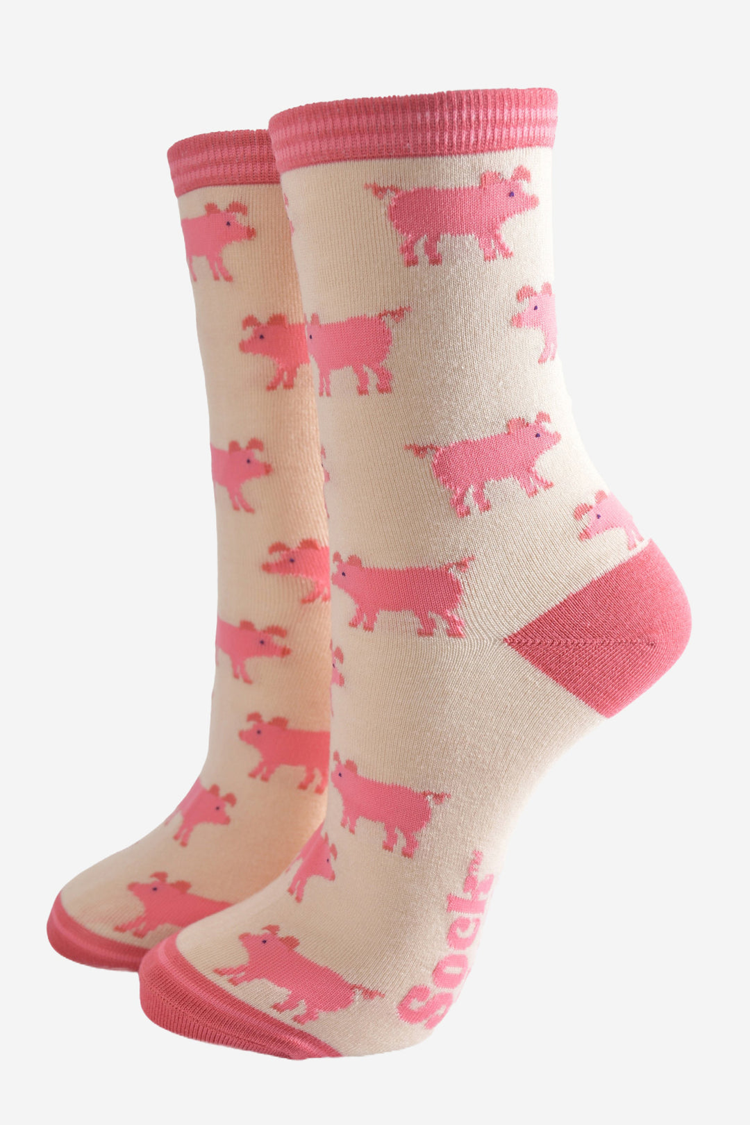 cream and pink bamboo socks with an all over pattern of pink pigs. the socks have a pink toe, heel and cuff