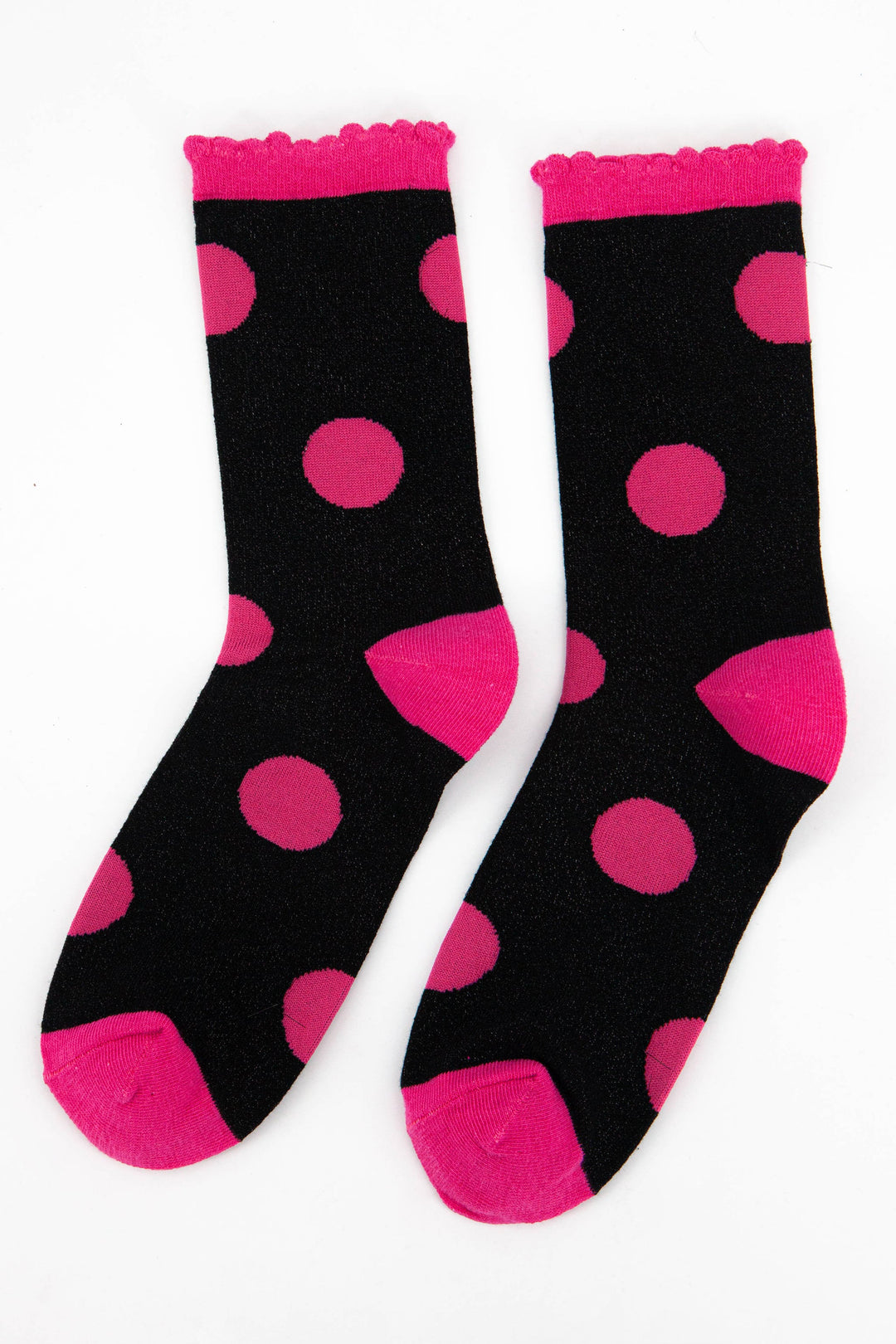 black and hot pink large polka dot pattern glitter socks laying flat, showing the all over glitter sparkle