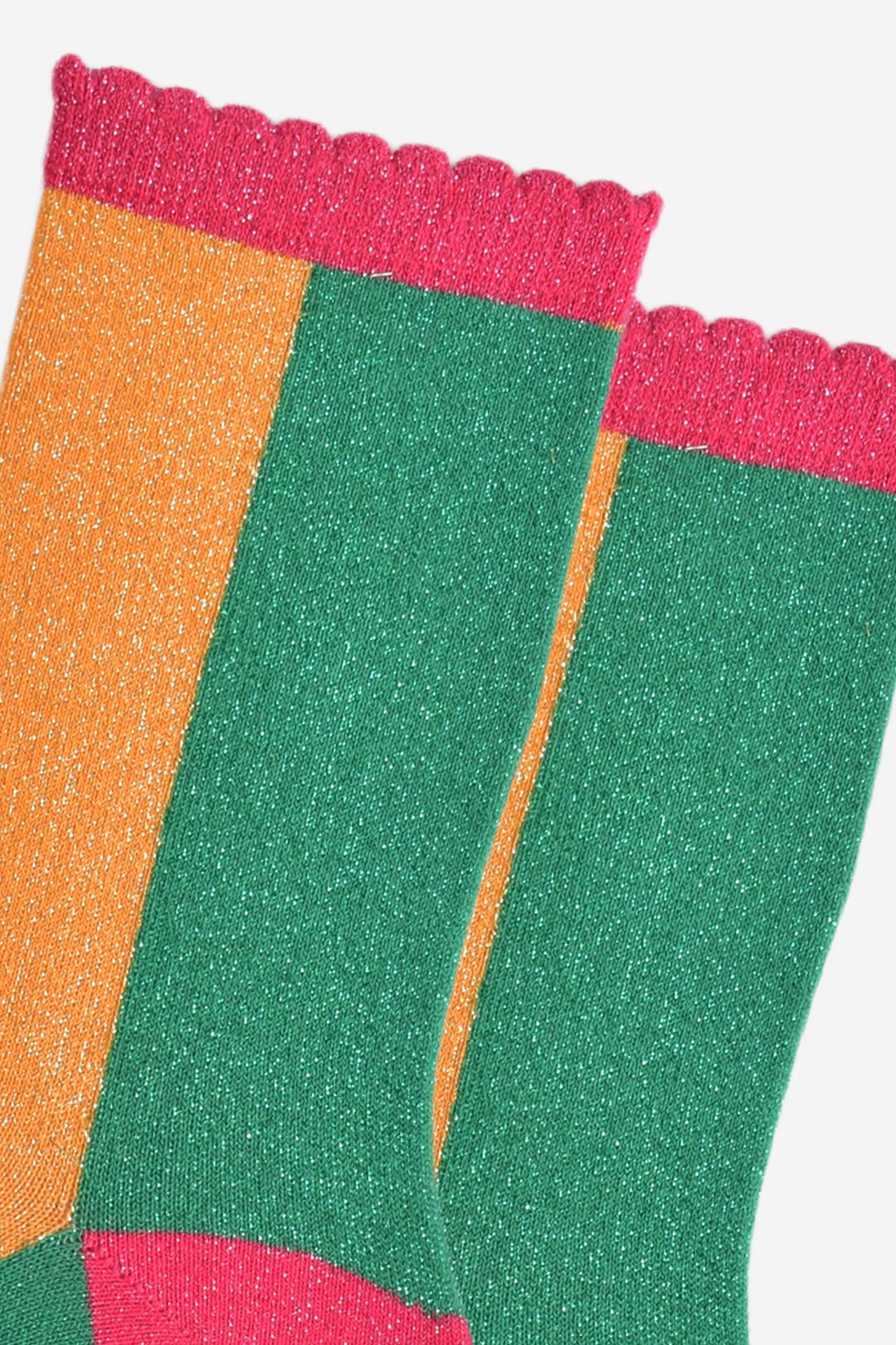 close up of the all over silver glitter sparkle on the green and orange colour block socks