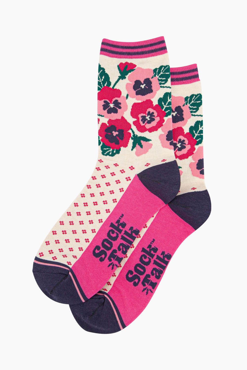 the pair of cream and pink pansy socks laying flat one overlapping the other. showing clearly the cream background of the socks which is contrasted by a fuchsia pink dotted pattern. on the ankle of the socks there is an arrangement of pink and fuchsia pansies. the sock talk logo is navy blue visible on the base of the sole