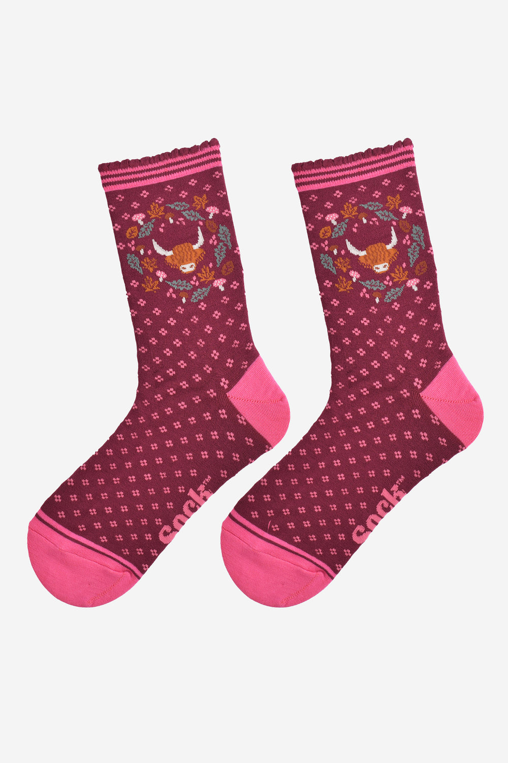 highland cow wreath bamboo socks laying flat, showing burgundy socks with an all over pink floral pattern and a highland cow surrounded by autumn foliage on the ankles