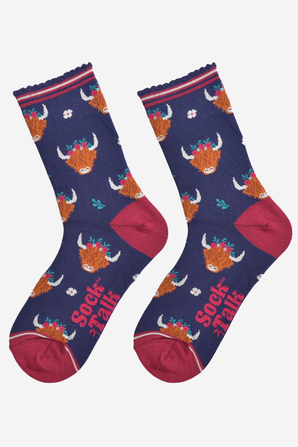 winter highland cow socks laying flat, showing the all over pattern of cow heads wearing festive floral crowns