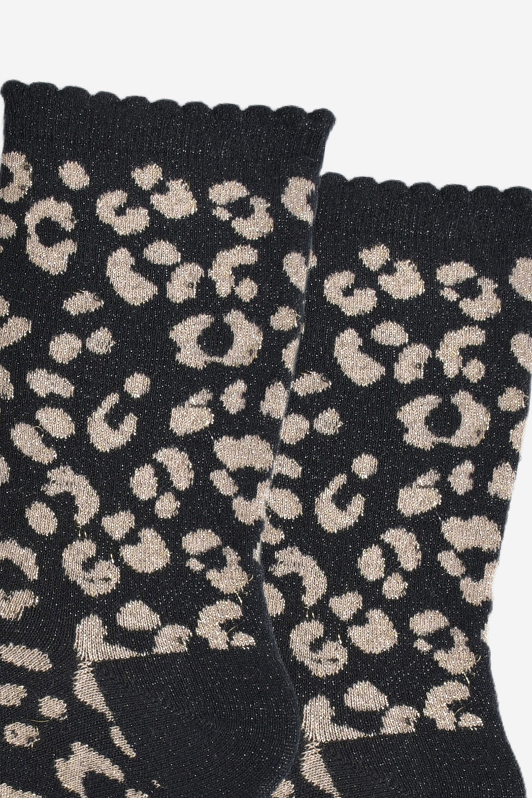 close up of the gold leopard print pattern on the socks, there is a visible silver glitter sparkle all over the design. the gold print contrasts with the black base of the socks