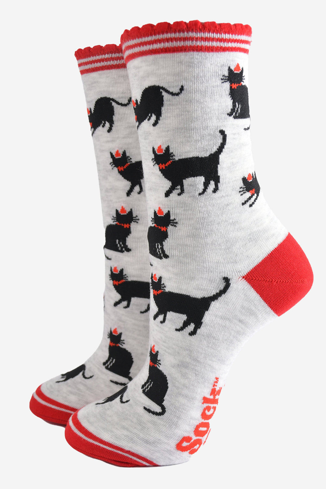 light grey socks with black cats wearing festive party hats, the socks have red striped scalloped cuffs, red toe and heel