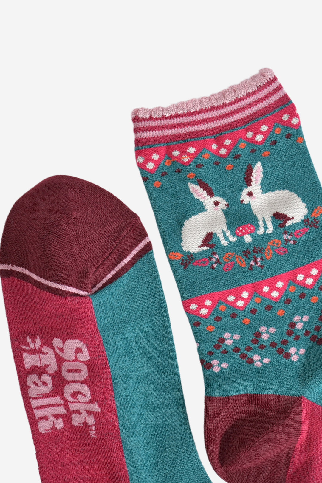 close up of the toe and cuff of the socks, the toe is burgundy red with a pink striped outline, the cuffs are scalloped and are pink with fuchsia stripes