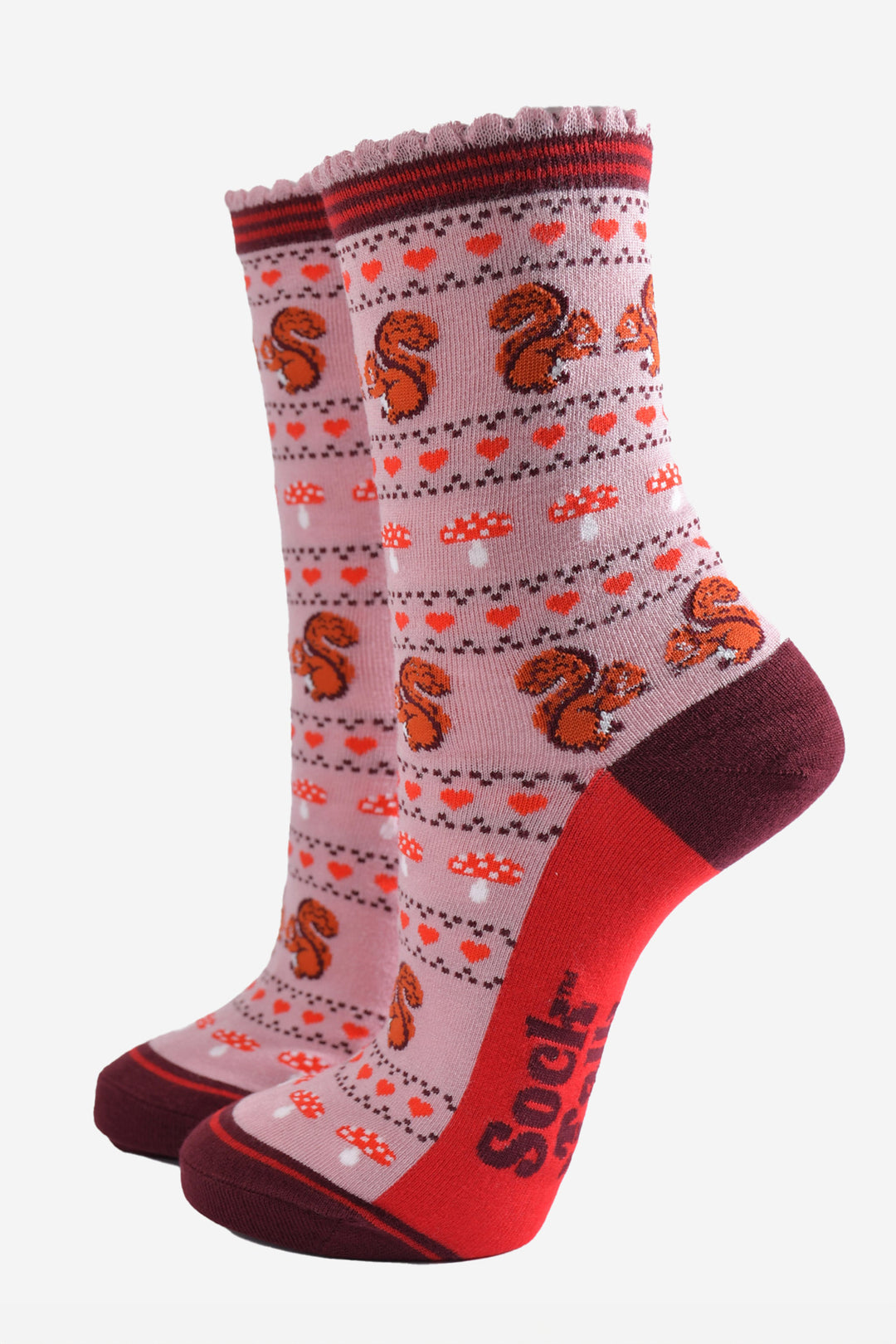 pink socks with a fair isle style pattern featuring toadstools, red love hearts and squirrels