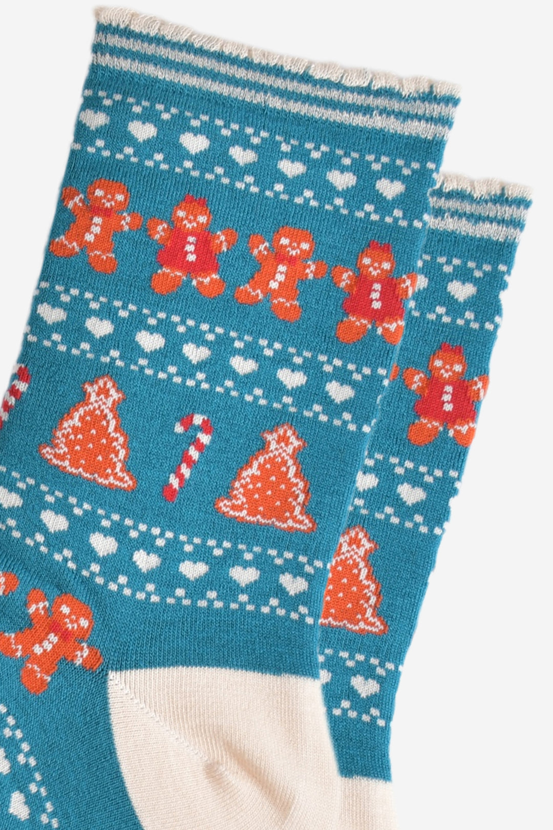 close up of the fair isle pattern, there are rows of gingerbread cookies men and women side by side, rows of white love hearts and rows of gingerbread xmas trees and candy canes.