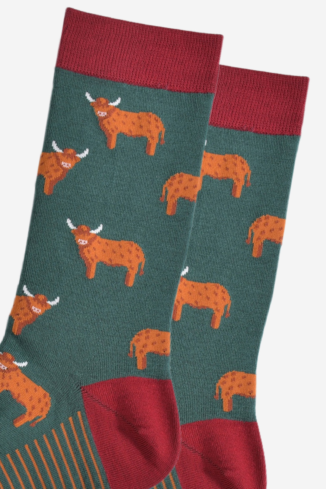 close up of the orange highland cows on the socks, the cows are standing up and they are designed to look like they have long hair