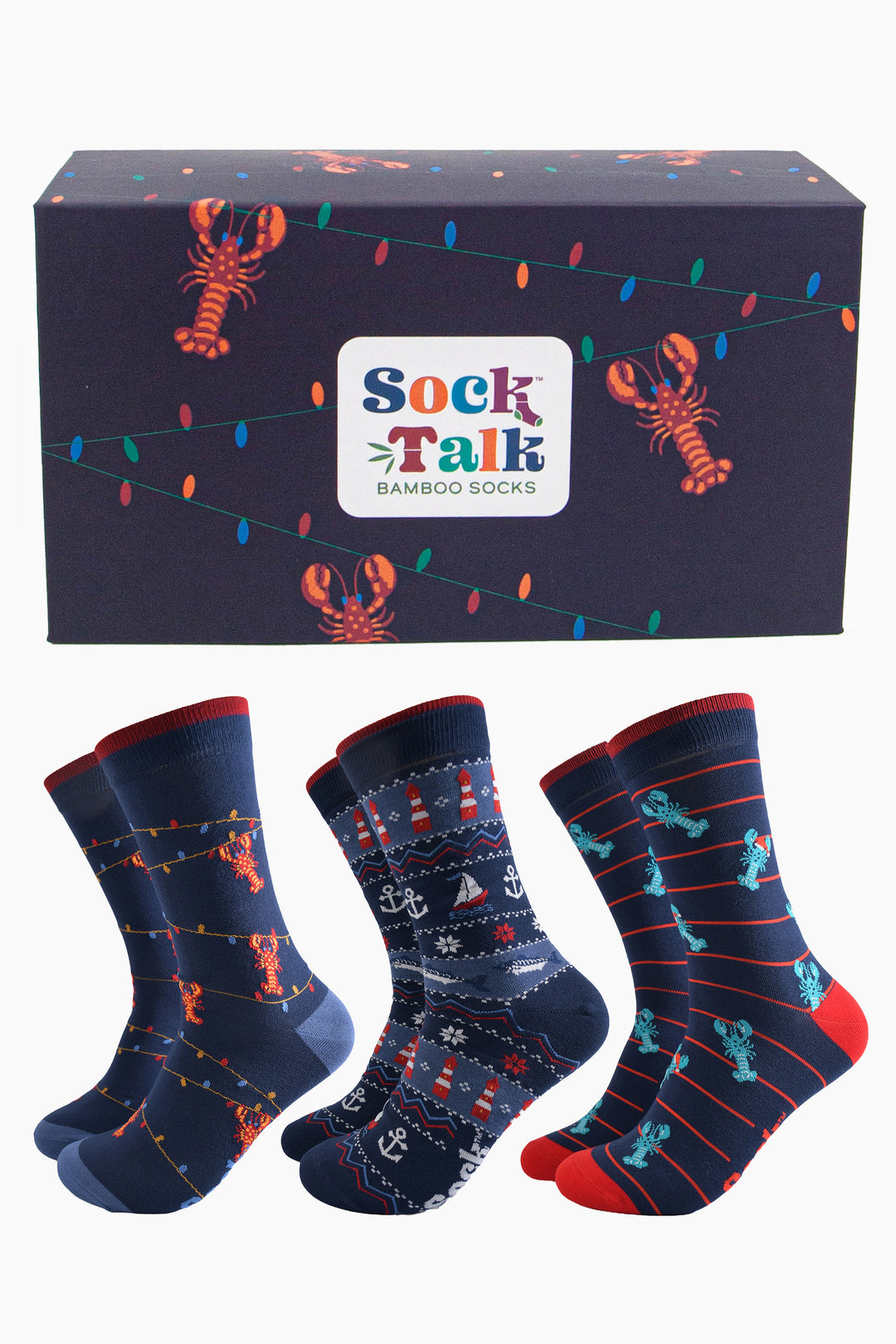 navy blue gift box with red lobsters dangling from colourful party lights, with three pairs of bamboo socks, blue lobsters wearing santa hats, fair isle nautical design featuring anchors, boats and lighthouses and one pair of red lobster socks showing them dangling from party lights