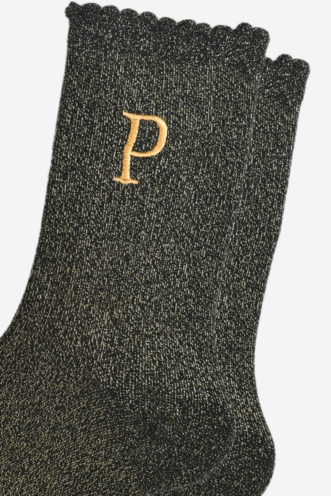 close up of the gold embroidered capital letter p on the ankle of the socks