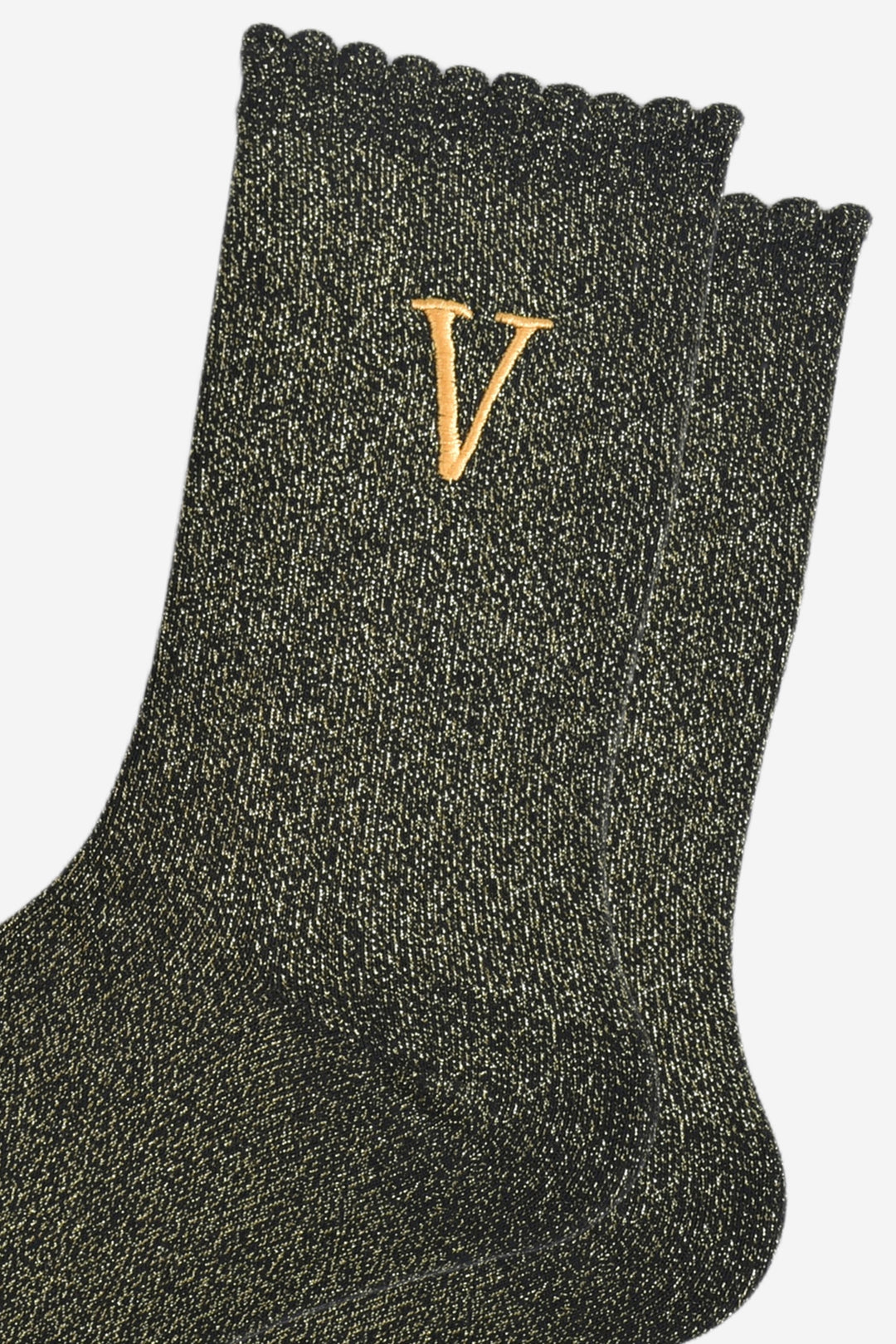 close up of the gold embroidered capital letter v on the ankle of the socks