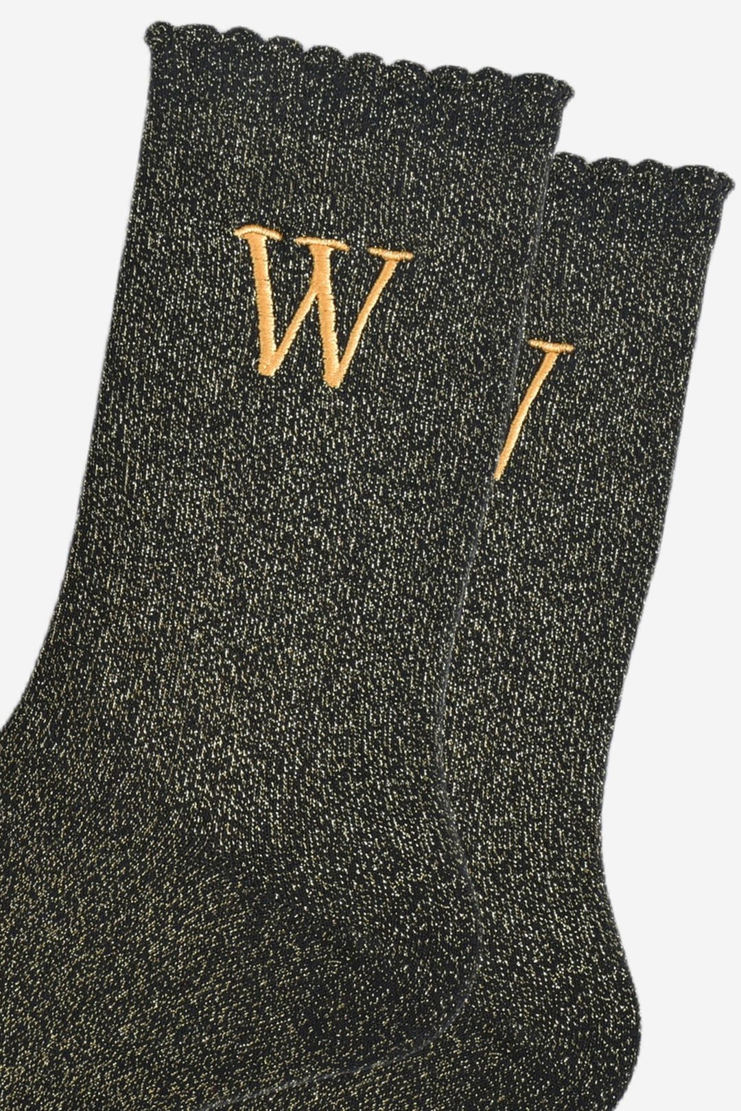 close up of the gold embroidered capital letter w on the ankle of the socks