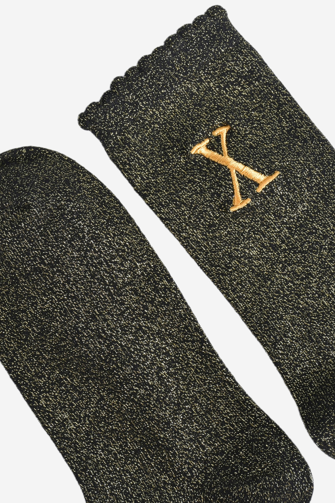 close up of the scalloped cuff on the socks, the toe is the same black and gold as the rest of the socks