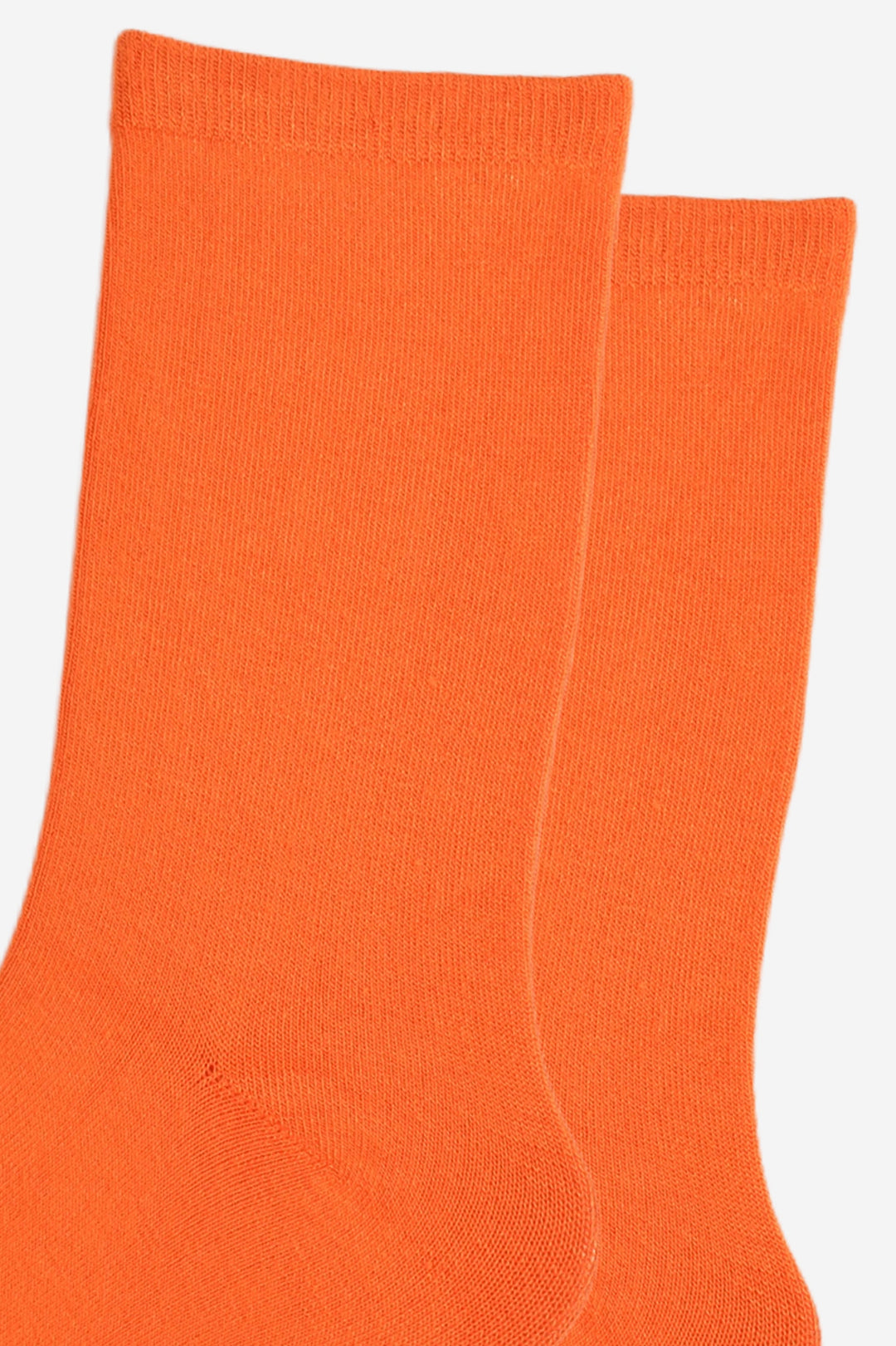 close up of the socks, showing the plain orange colour and the classic straight cuff