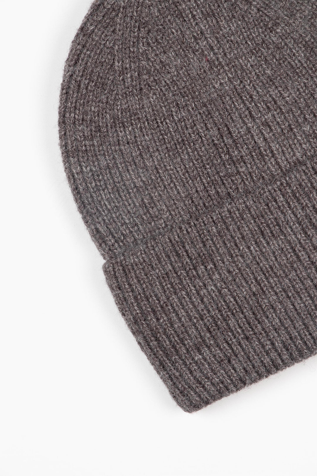 close up of the brim of the dark grey knitted beanie hat, showing the ribbed design