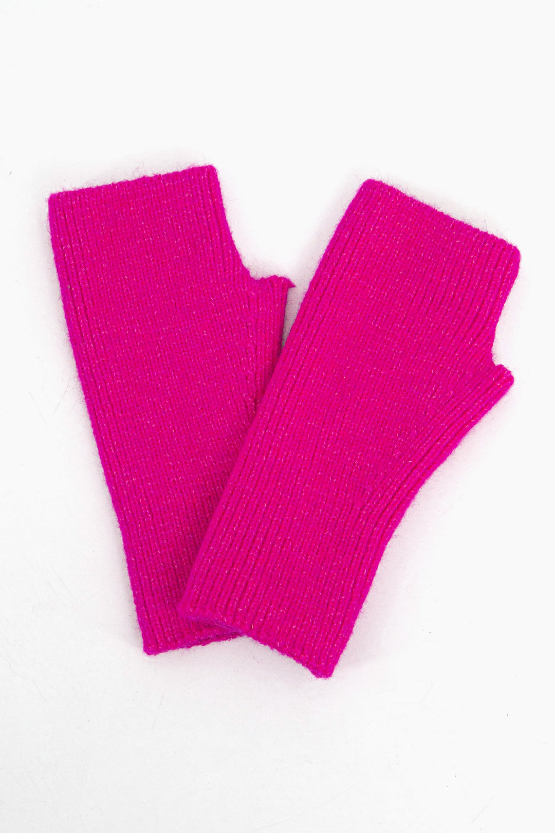 close up of the fuchsia pink wrist warmers, showing he knitted design and the defined thumb hole feature.