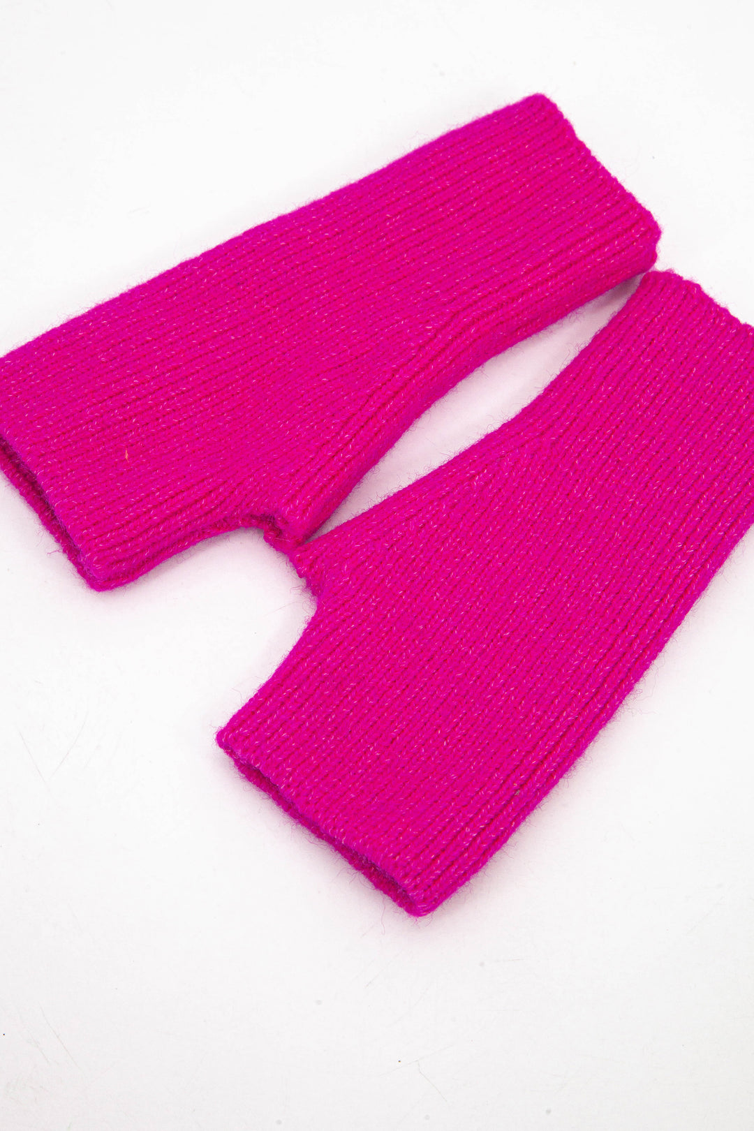 side view of the wrist warmers, showing the openings at each end and the knitted design.