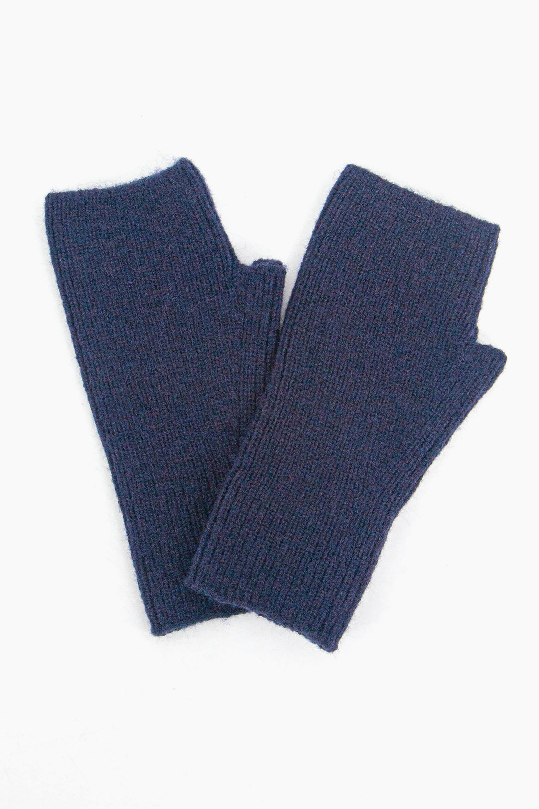 close up of the navy blue wrist warmers, showing he knitted design and the defined thumb hole feature.