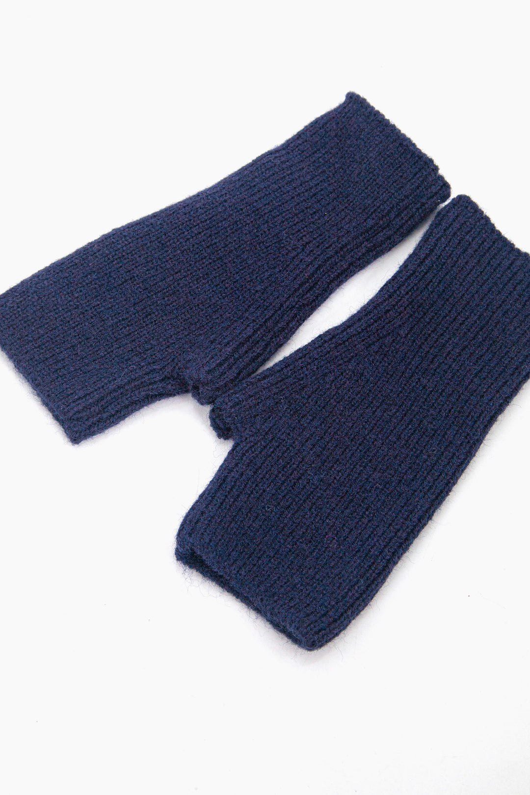side view of the wrist warmers, showing the openings at each end and the knitted design.