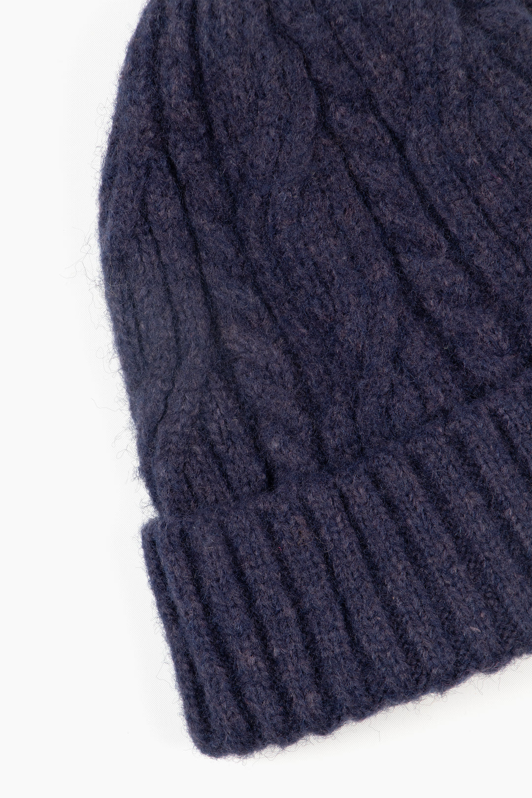 close up of the ribbed brim of the beanie hat and of the cable knit pattern.