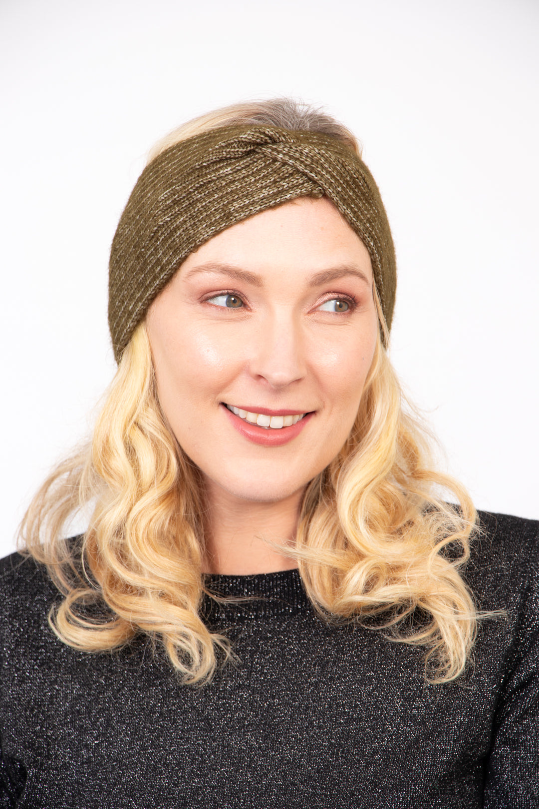 model wearing a khaki knitted twist front headband, the band covers the ears and forehead