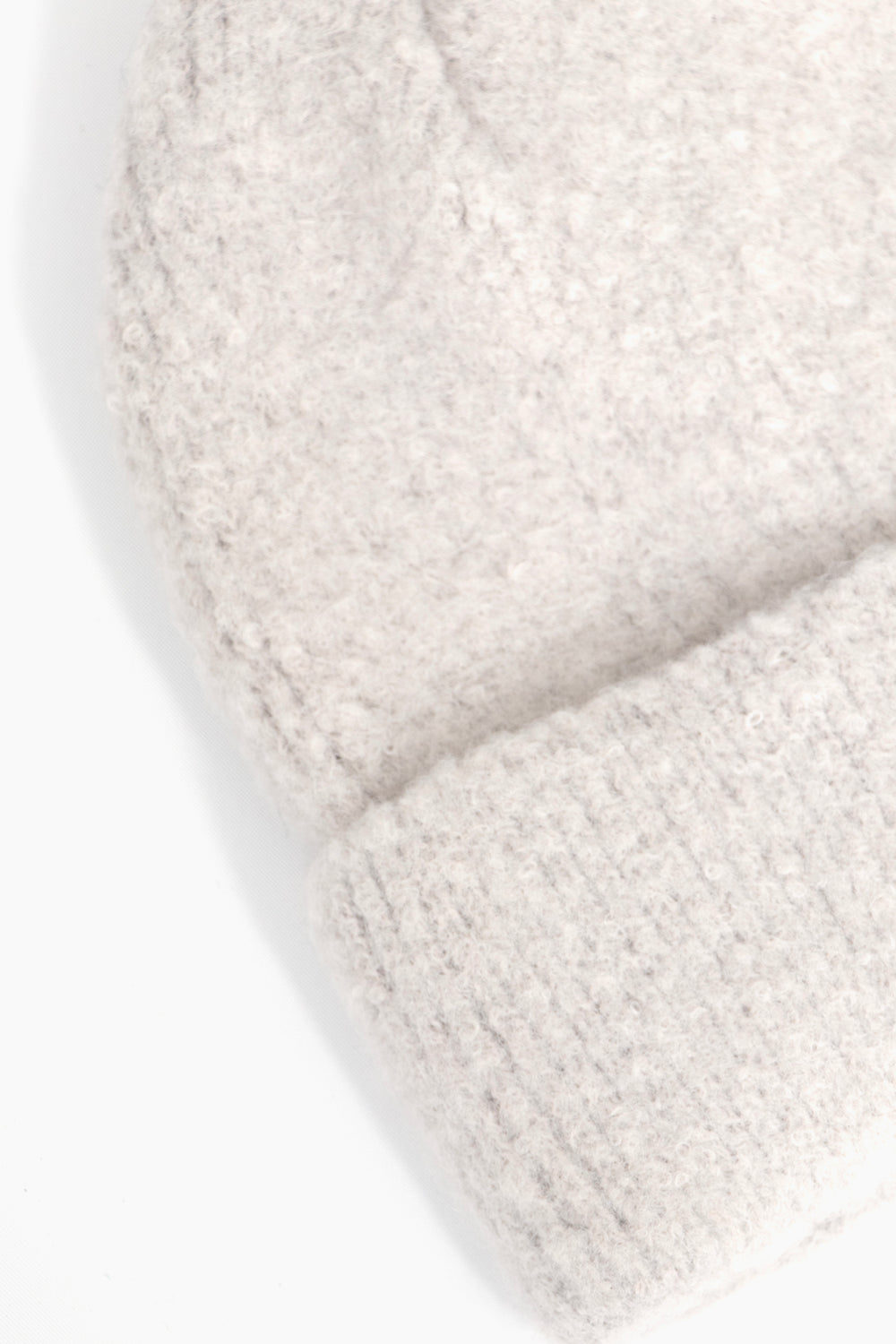 close up of the fluffy textured knitted fabric of the beanie hat.