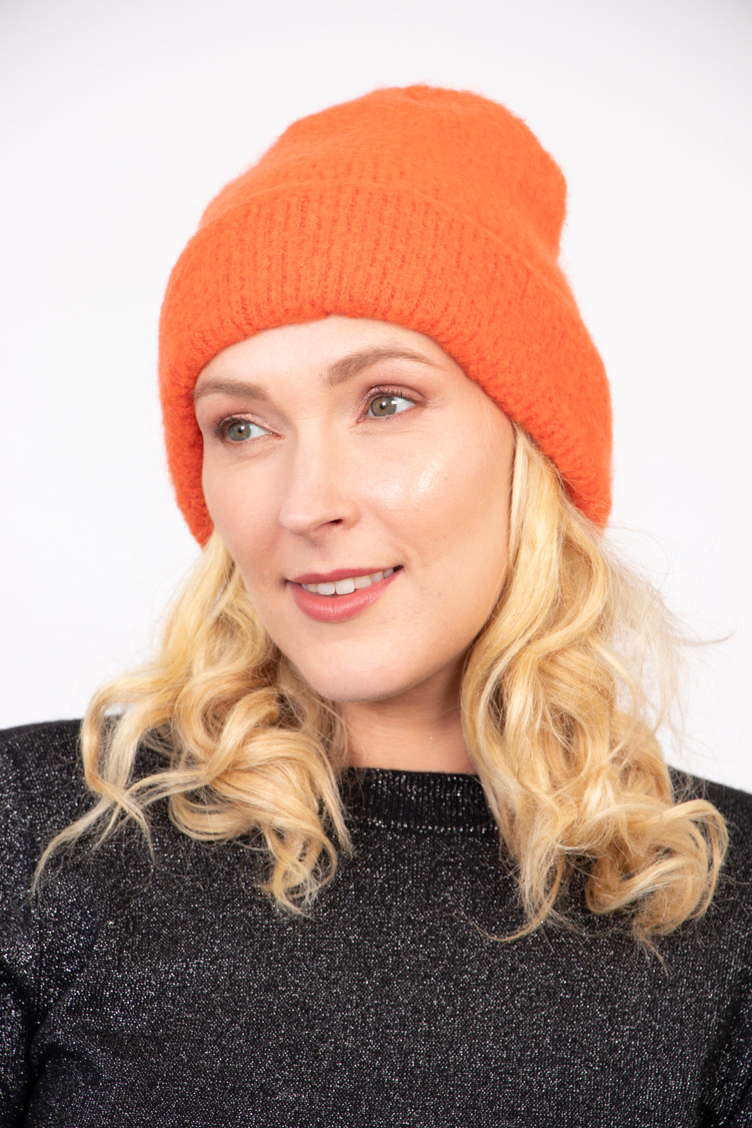 model wearing a textured knitted plain orange beanie hat