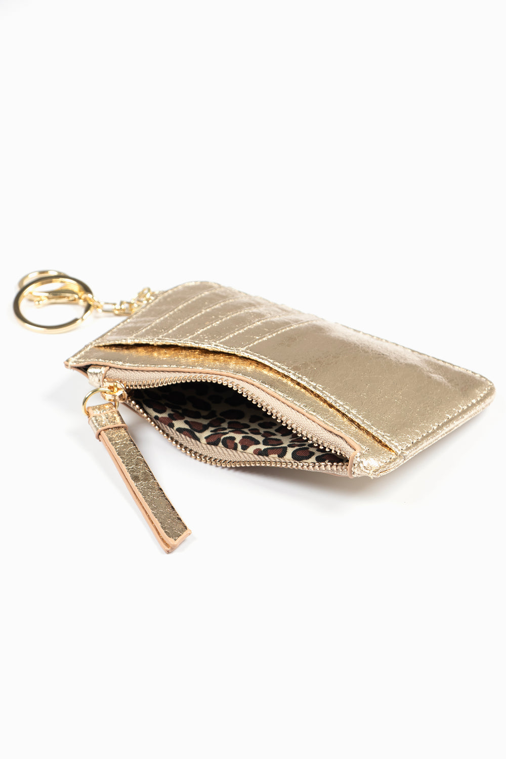 showing the gold card holder laying flat, there is an open zip pocket compartment, also showing are the card slots on the outside of the item 