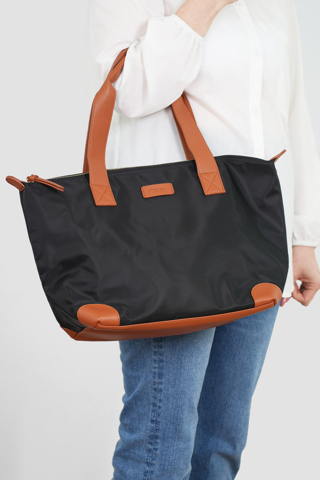 model holding the bag over the arm, showing the large size of the item