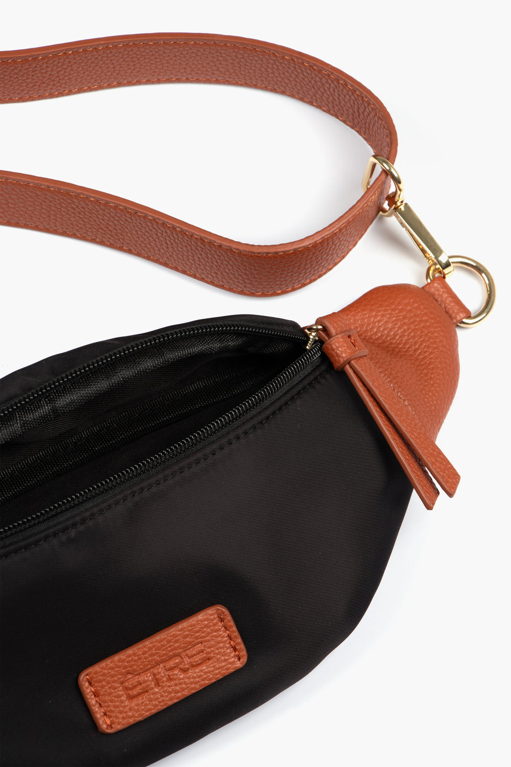 close up of the open bum bag showing also the tan faux leather strap and gold hardware