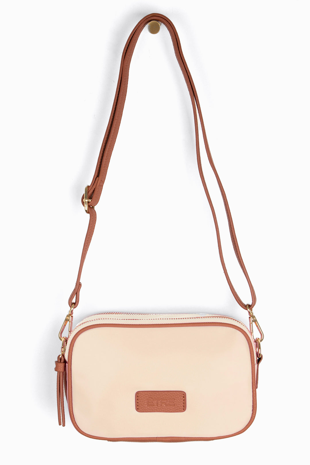 cream crossbody bag with tan faux leather accents and a detachable strap