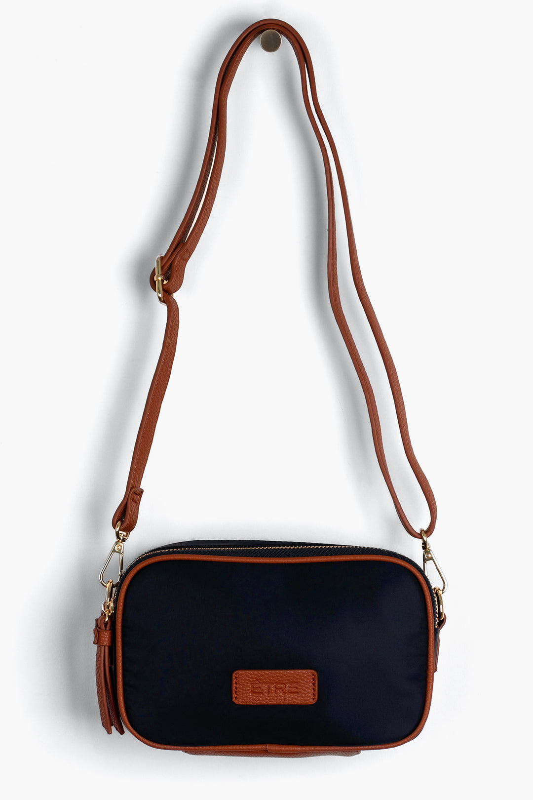 navy blue crossbody bag with tan faux leather accents and a detachable strap