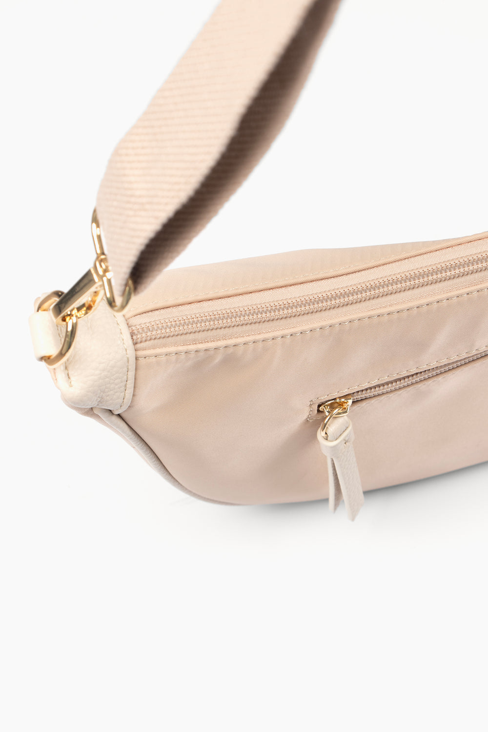 close up of the back of the bag, showing two zip closing compartments. One large compartment accessible from the top of the bag, the other is a smaller side pocket accessible on the back.