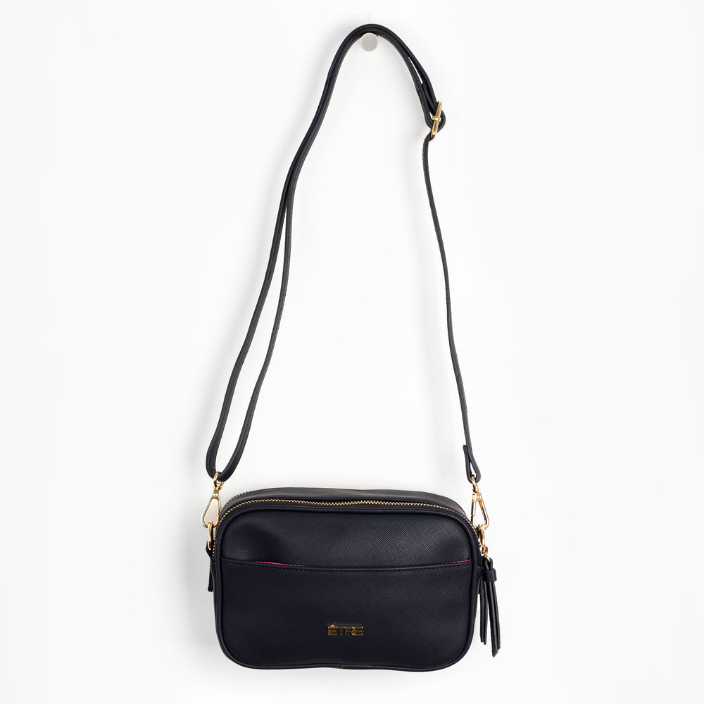 navy blue faux leather cross body bag, with a detachable adjustable strap. the bag has two zip fastening compartments and a front pocket