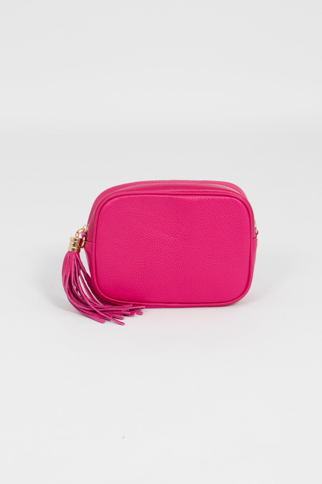 raspberry pink crossbody camera bag with a decorative tassel and gold zip closure