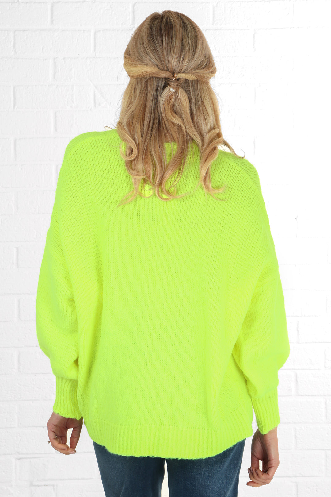 model showing the back of the neon yellow cardigan showing an all over solid colour