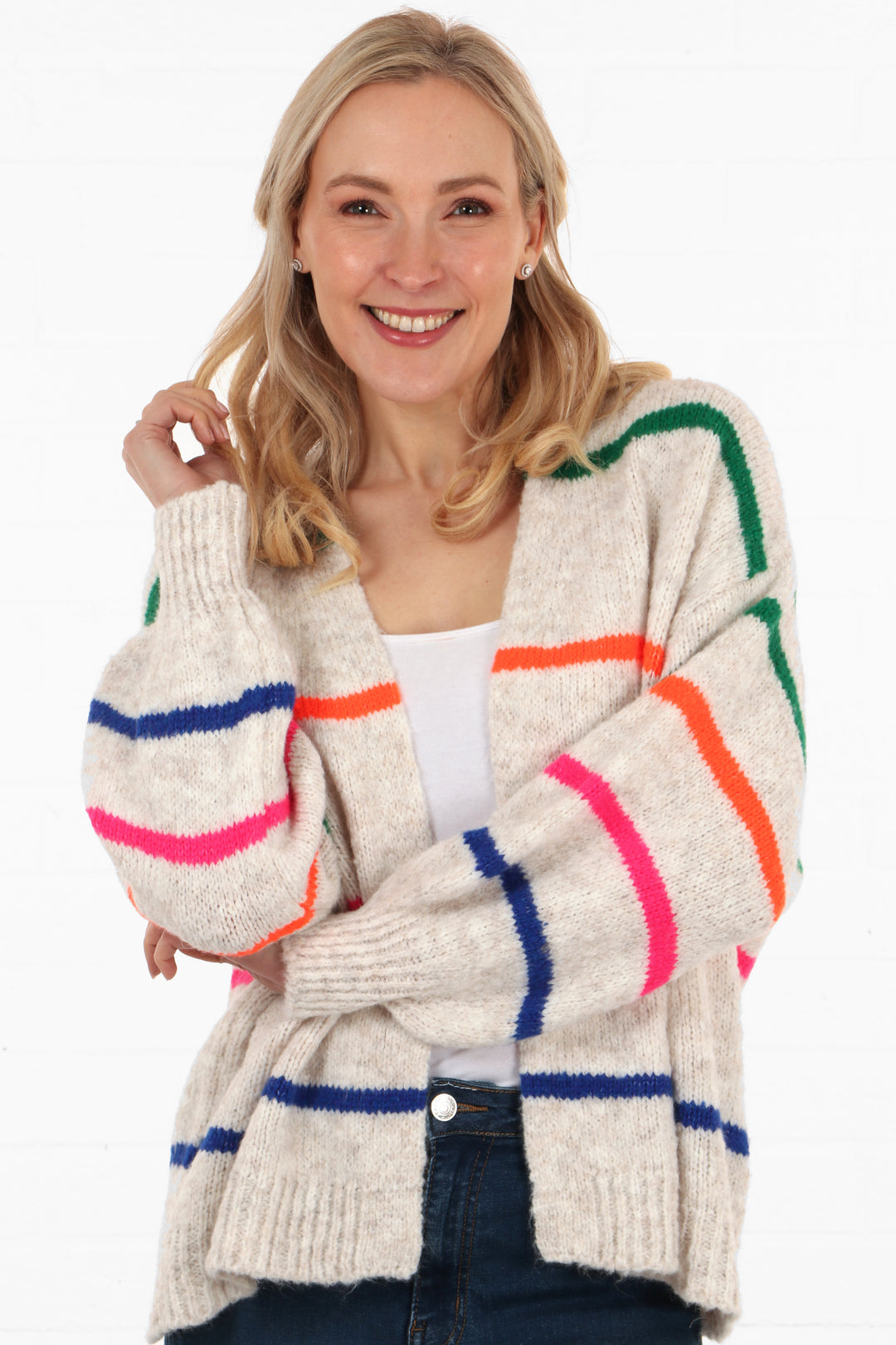 model wearing a cream knitted short cardigan with multicoloured horizontal stripes