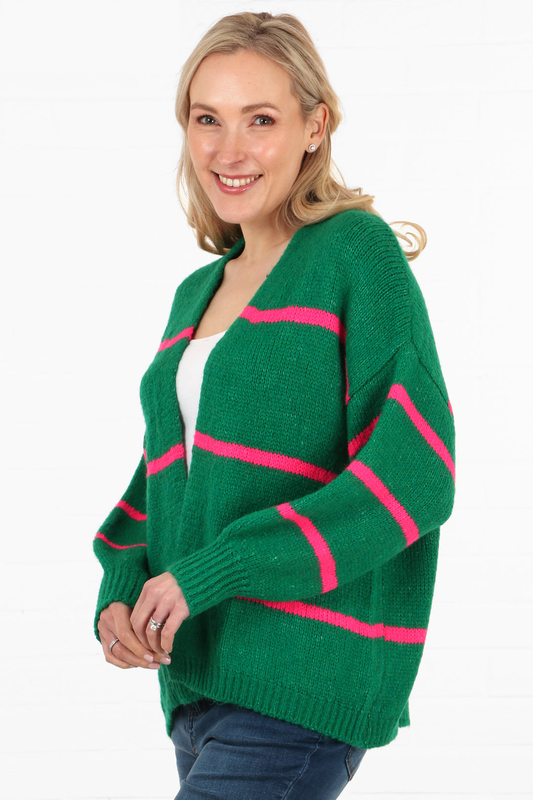 model showing a side view of the cardigan, showing that the sleeves also have the three pink stripes on them