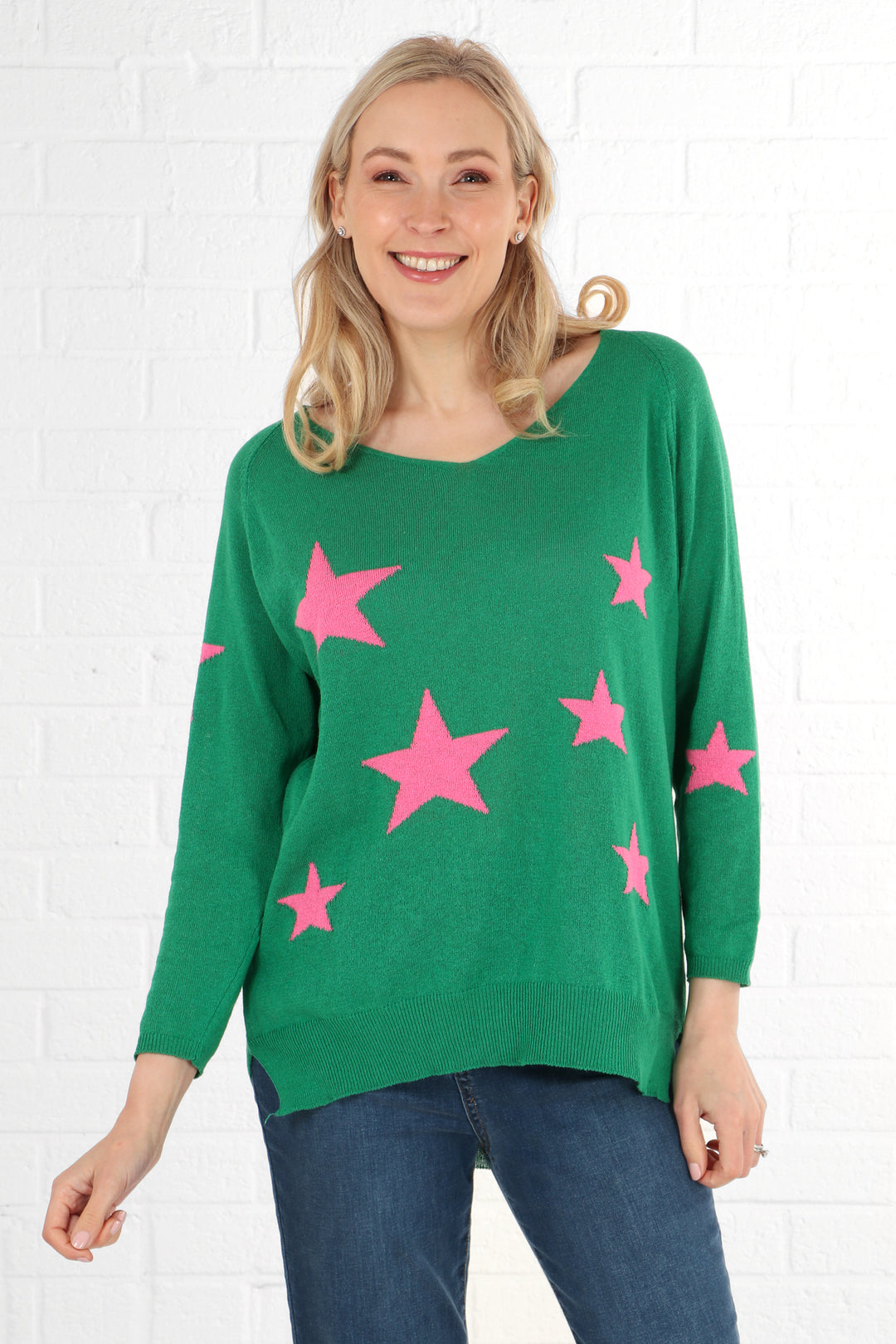 model wearing a green and pink star print long sleeve jumper made from natural cotton