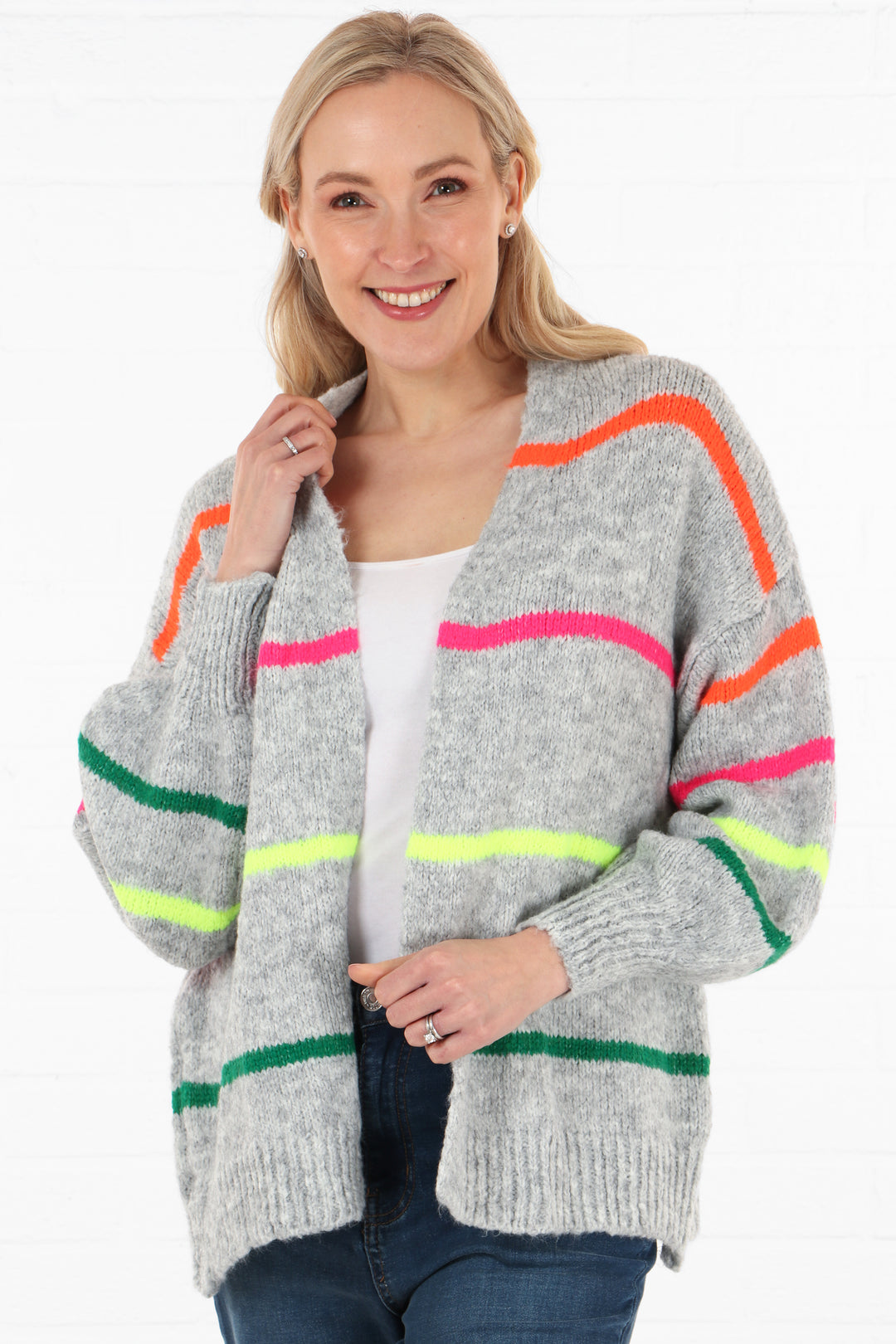 model wearing a light grey knitted cardigan with multicoloured horizontal stripes