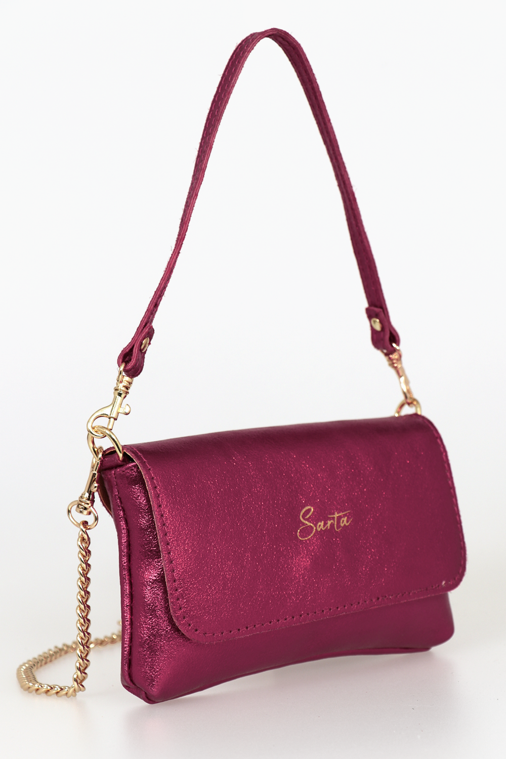 side view of the small cross body bag, showing the folding front closure, gold chain strap and detachable handle strap