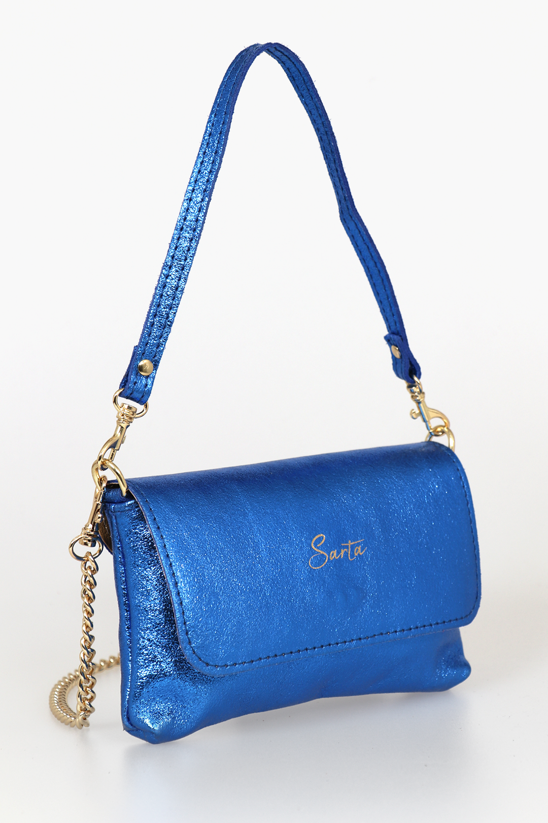 side view of the small cross body bag, showing the folding front closure, gold chain strap and detachable handle strap