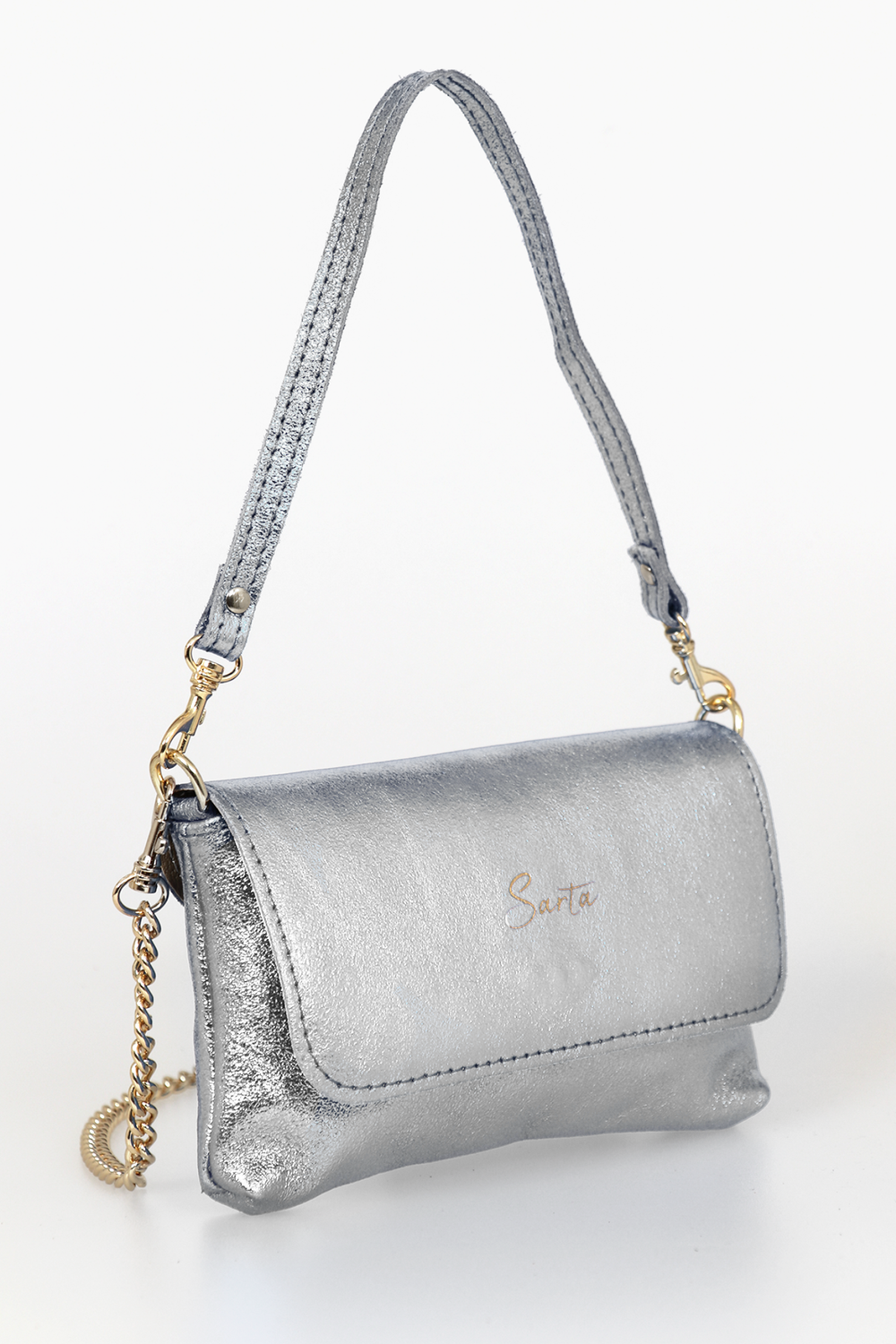 side view of the small cross body bag, showing the folding front closure, gold chain strap and detachable handle strap