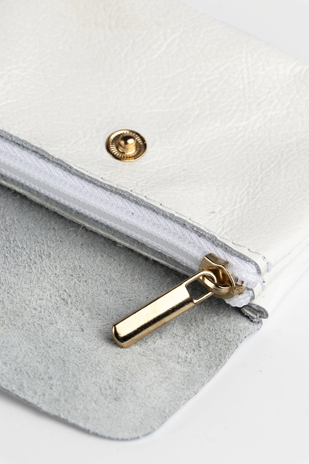 showing the inside of the white leather coin purse and the secure zip closure